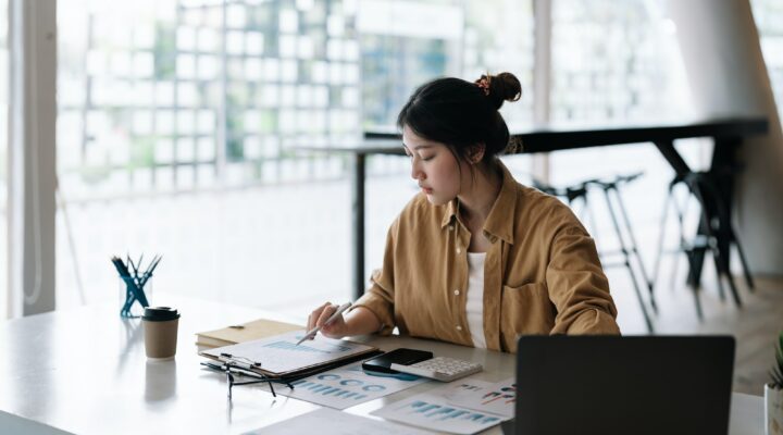 Accountant business woman using calculator and computer laptop, budget and loan paper in office