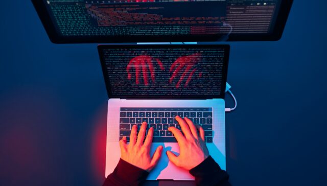 Man using computer and programming to break protection. Cyber security threat. Cyber attack