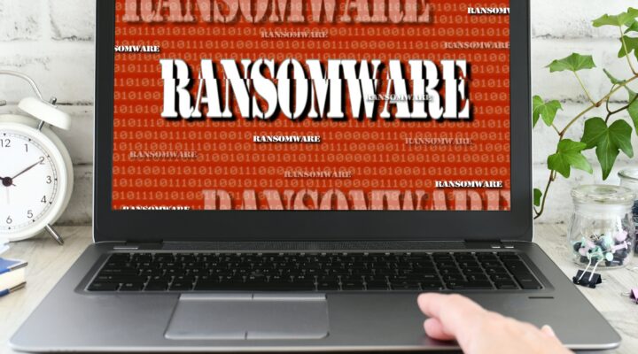 Person working on a laptop computer that has been seized by a ransomware cyber attack. hacked virus