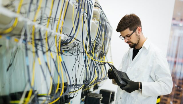 Picture of network technician testing modems in factory