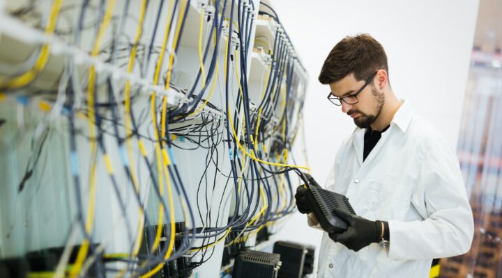 Picture of network technician testing modems in factory